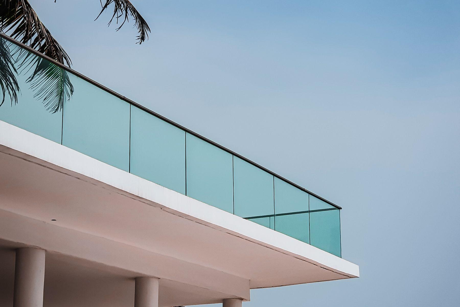 A modern residential building under a bright tropical sky
